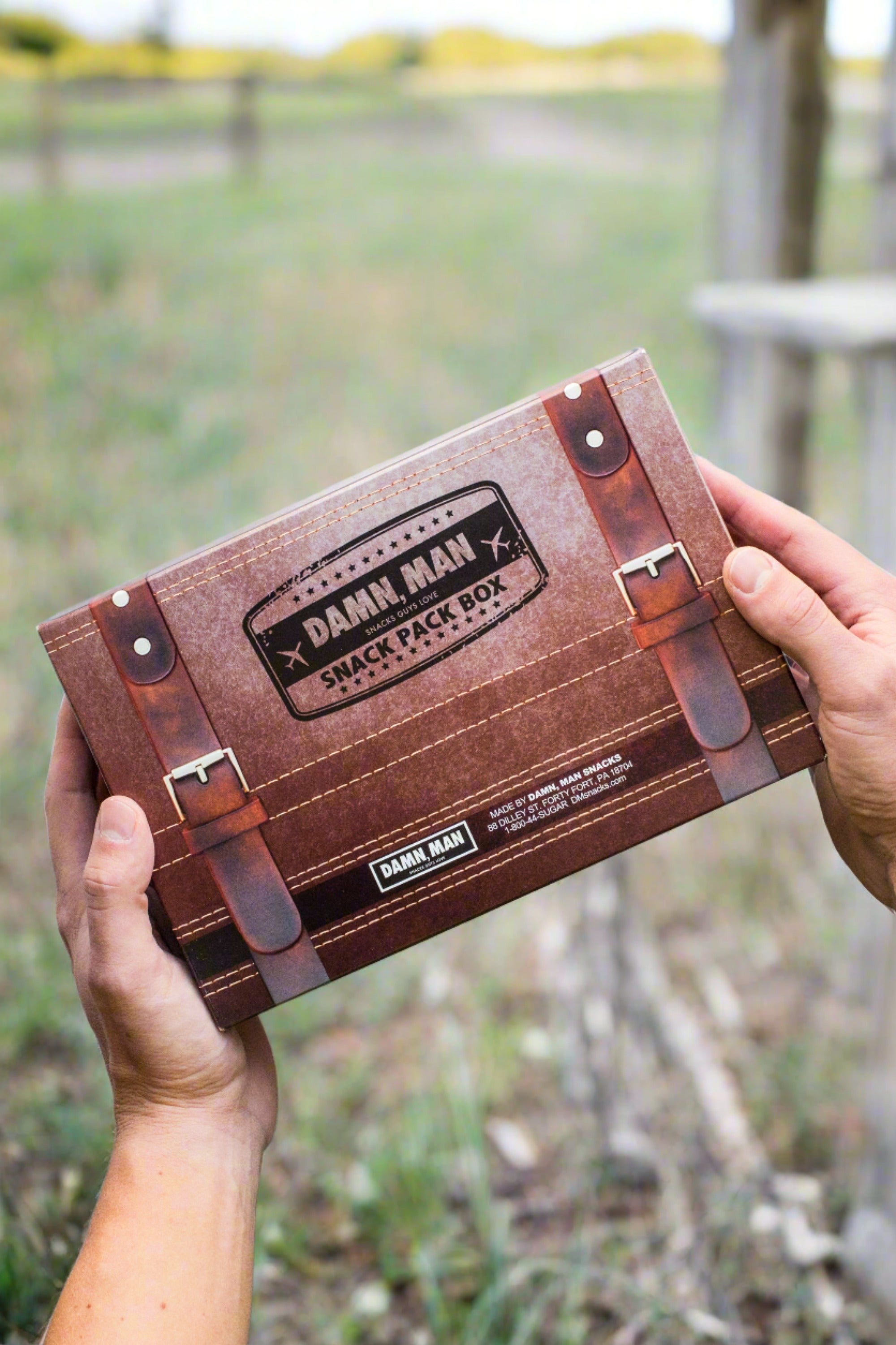 Damn, Man Build Your Own 4-Pack Box Mixed Nuts held outdoors, perfect personalized snack gift box for men.