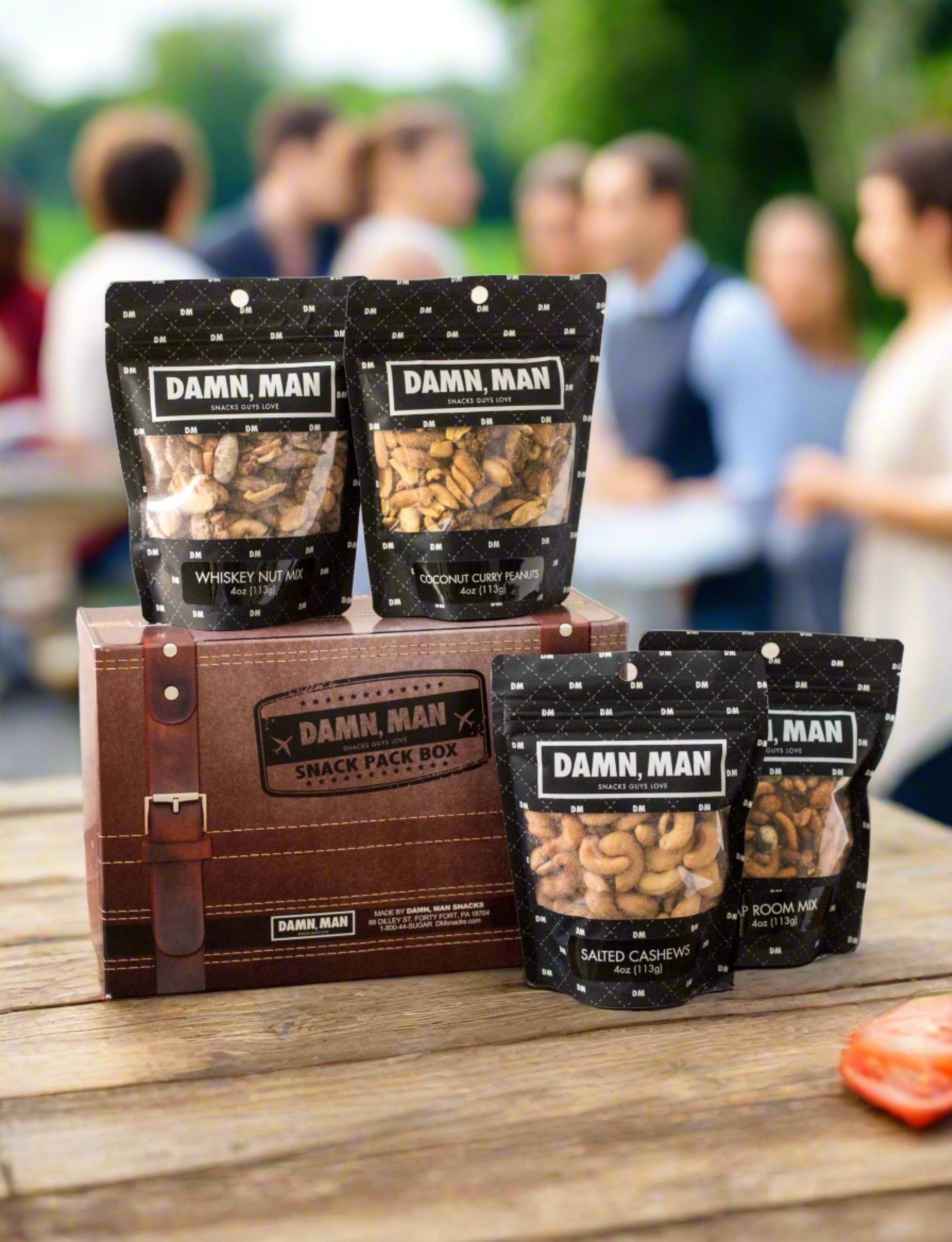 Build Your Own 4-Pack Box Mixed Nuts with Damn, Man Snacks on display at an outdoor gathering. Protein-packed gourmet nut snack box. Perfect for Fathers Day Gift or gifts for him