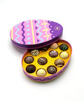 Colorful chocolate truffles in an Easter-themed tin on a white background