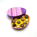 Colorful chocolate truffles in an Easter-themed tin on a white background