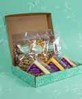Snack box with various food items on a green background