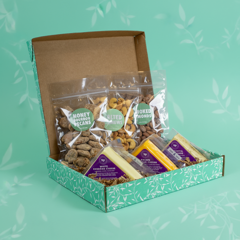 Snack box with various food items on a green background